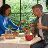 Man and woman in a kitchen with a modern faucet and greenery outside