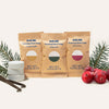 Three Holiday Hand Soap Tablet Refills—Toasted Vanilla, Wintry Pine, and Winterberry—are displayed with pine sprigs, cranberries, vanilla beans, and Foaming Hand Soap tablets on a light background.