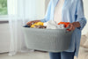A person in casual clothing holding a full laundry basket