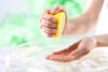 A person squeezing a lemon half into their palm 