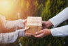 Two people exchanging a wrapped gift box