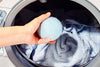 Putting a wool dryer ball into the dryer