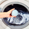 Putting a wool dryer ball into the dryer