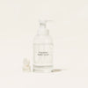 A clear glass foaming hand soap dispenser labeled FOAMING HAND SOAP and BLUELAND stands next to three white round refill tablets on a neutral background.